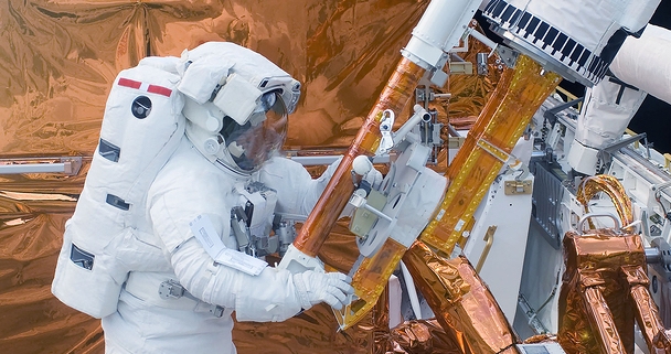 The Astronaut In A Space Suit, In An Outer Space, Is Engaged In Repair Of The Space Station. Element